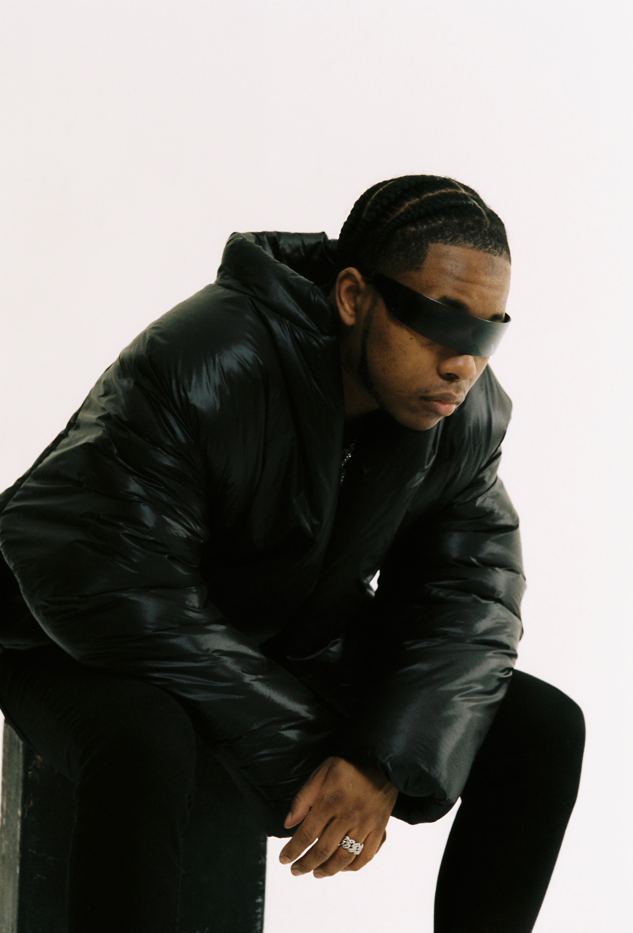 Person wearing a black leather jacket and sunglasses on a white background